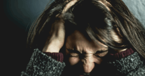 Woman experiencing antidepressant withdrawal symptoms or insufficient dose. Mental health concept showing distress, headache, and depression.