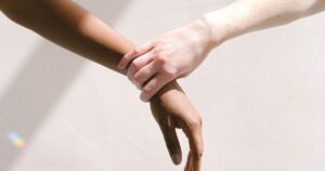 - Visalia Recovery Center Two hands of different skin tones clasped together in a gesture of support and solidarity.